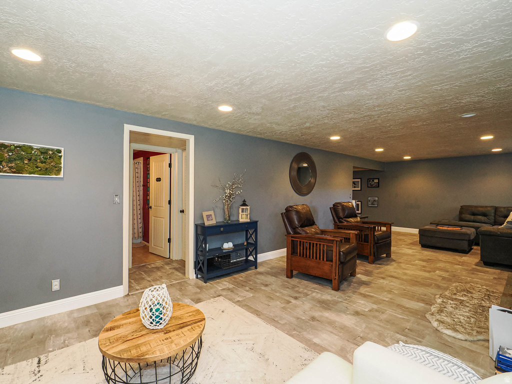 Spacious room with wood-finish flooring, recessed ceiling lighting, and crisp white baseboards