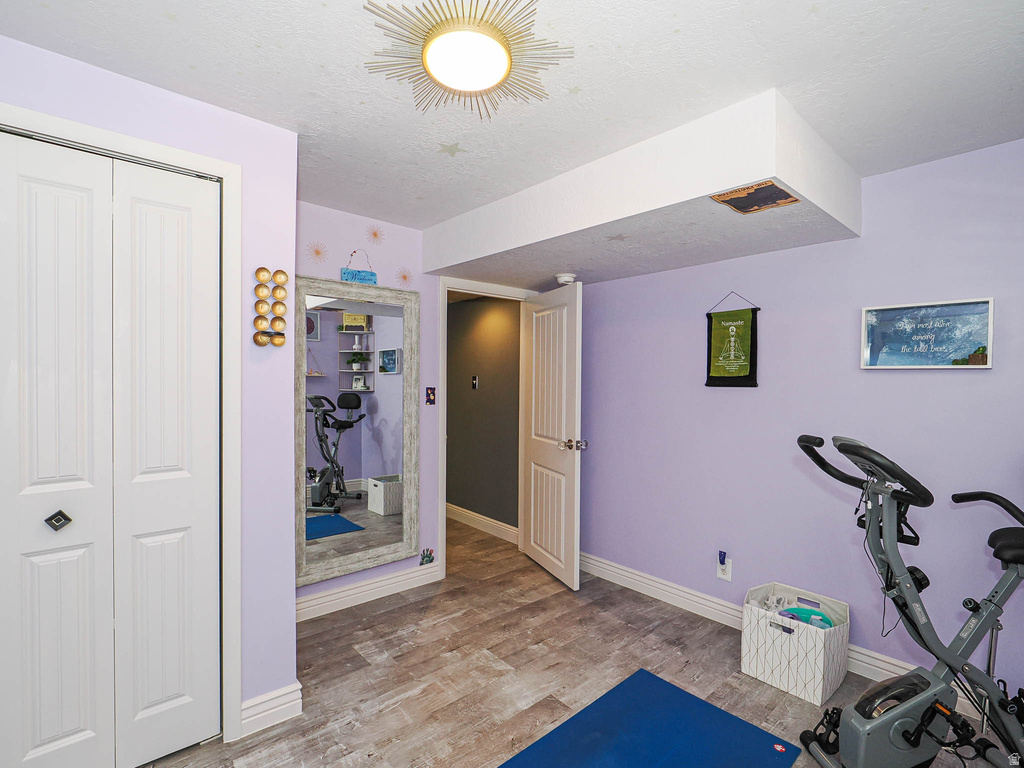 Interior room featuring wood-finish flooring, light purple wall paint, and white trim
