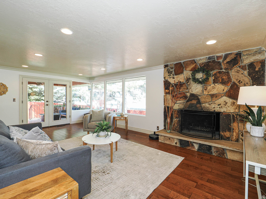 Living area featuring a stone fireplace with hearth, recessed lighting, and wood-finish flooring