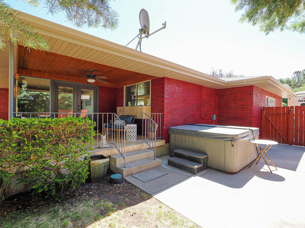 Covered patio featuring wood-finish soffit, ceiling fan, and double-pane glass doors