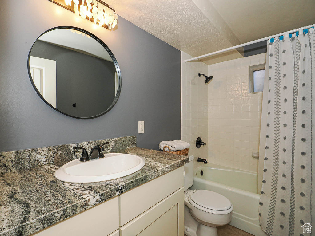 Bathroom featuring a vanity with a patterned countertop, an undermount sink, and dark bronze fixtures