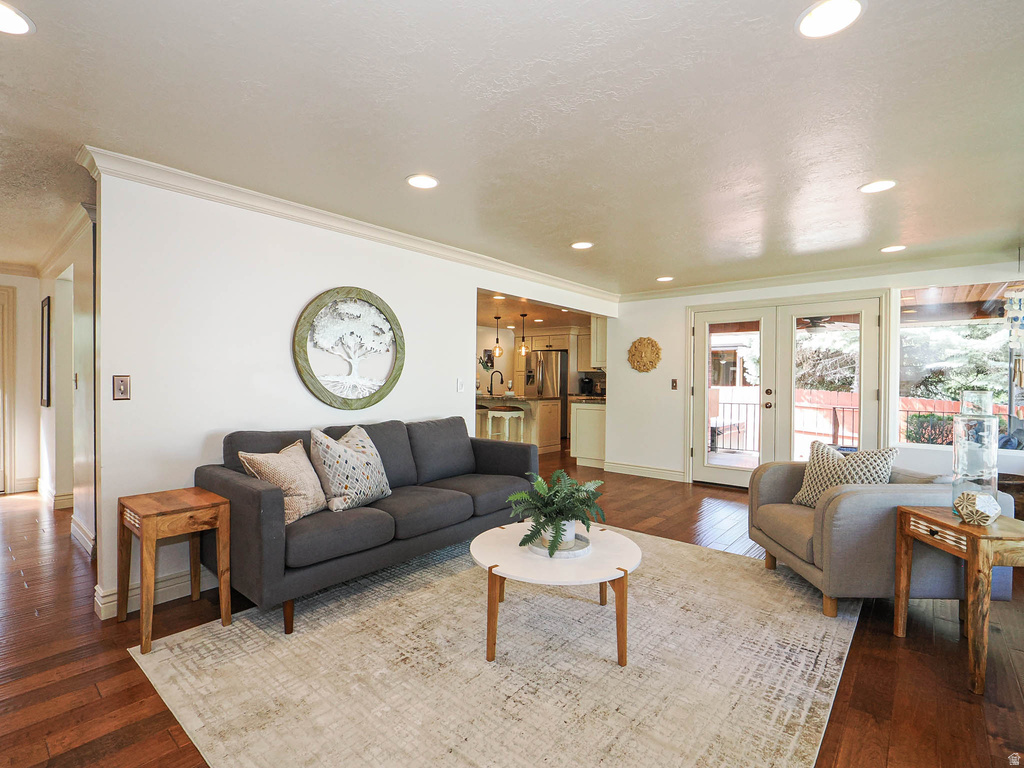 Living area featuring wood-finish flooring, recessed lighting, and crown molding