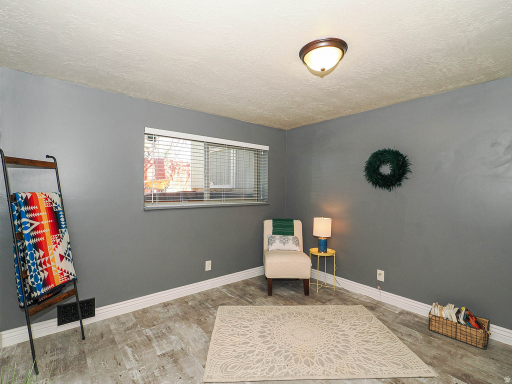 Room with wood-finish flooring, neutral gray walls, and white baseboards