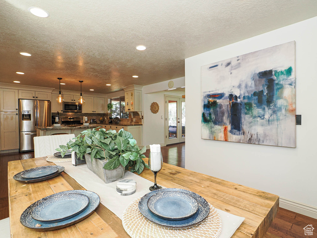 Open-concept dining area featuring a wood-finish table and recessed ceiling lighting