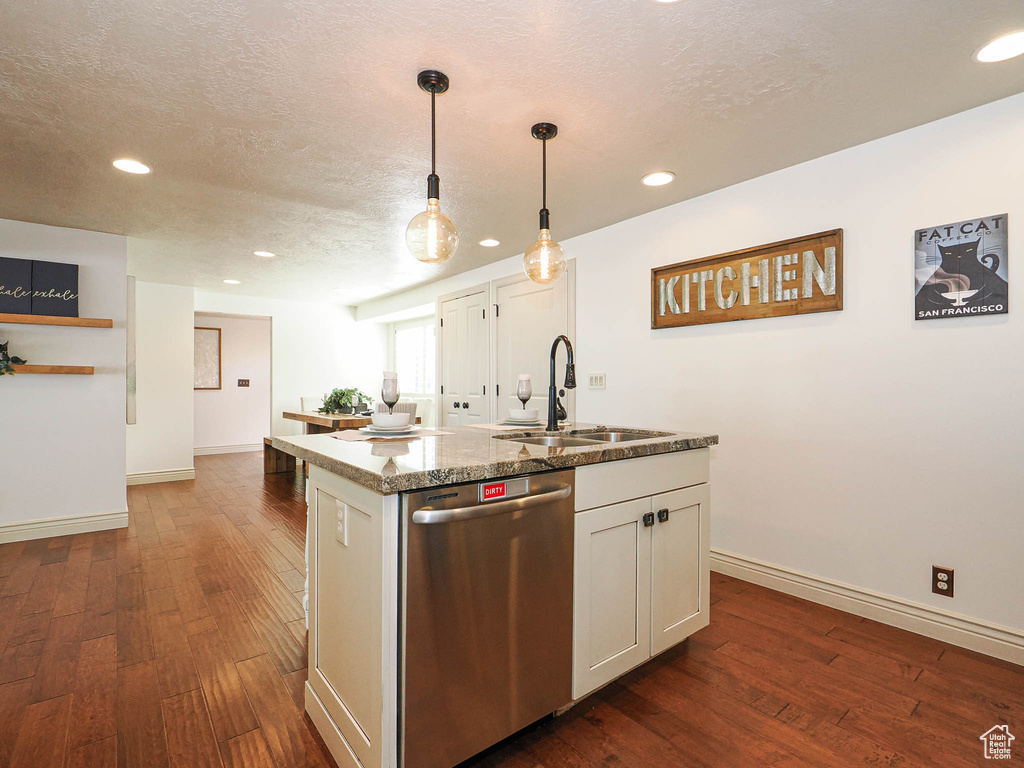 Kitchen island with an undermount double sink, stainless steel dishwasher, and a granite-style countertop
