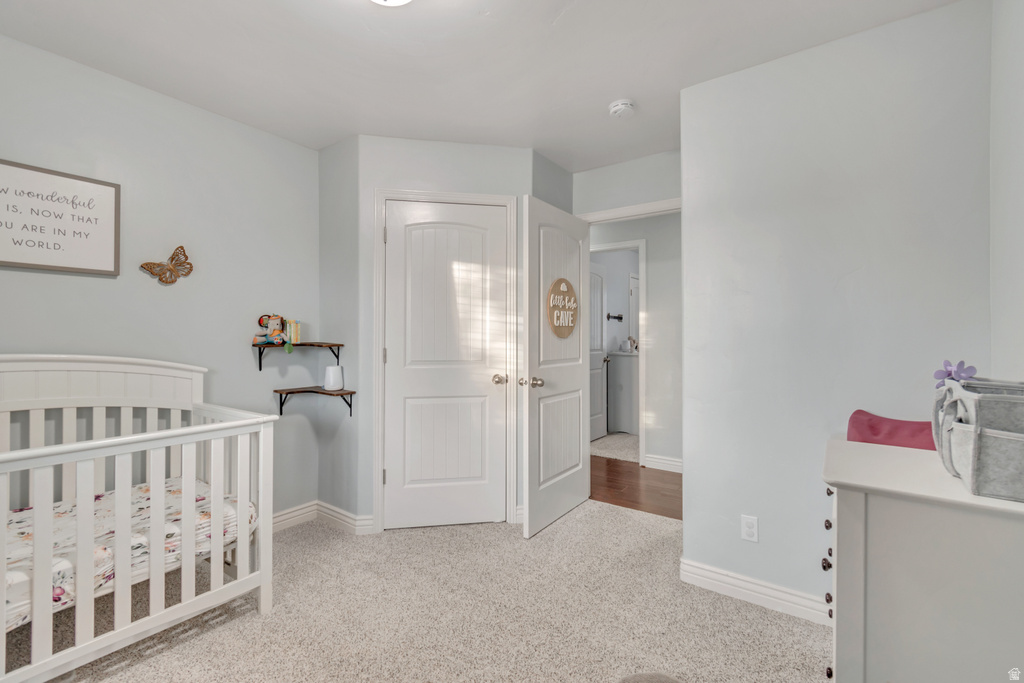 Carpeted room with light blue wall paint, white trim, and a white paneled door