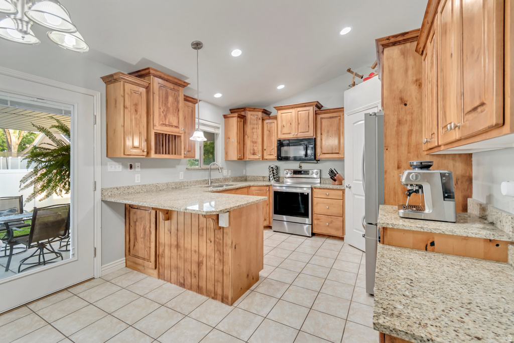 Kitchen featuring wood cabinetry, light-toned granite countertops, stainless steel appliances, and tile flooring
