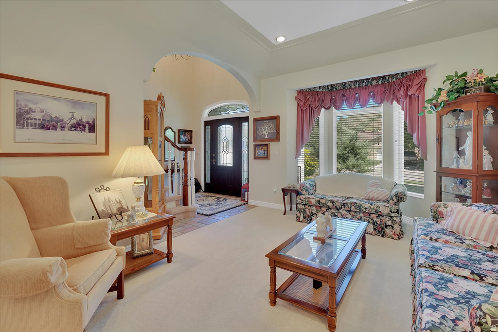Neutral-toned living area featuring a tray ceiling with recessed lighting