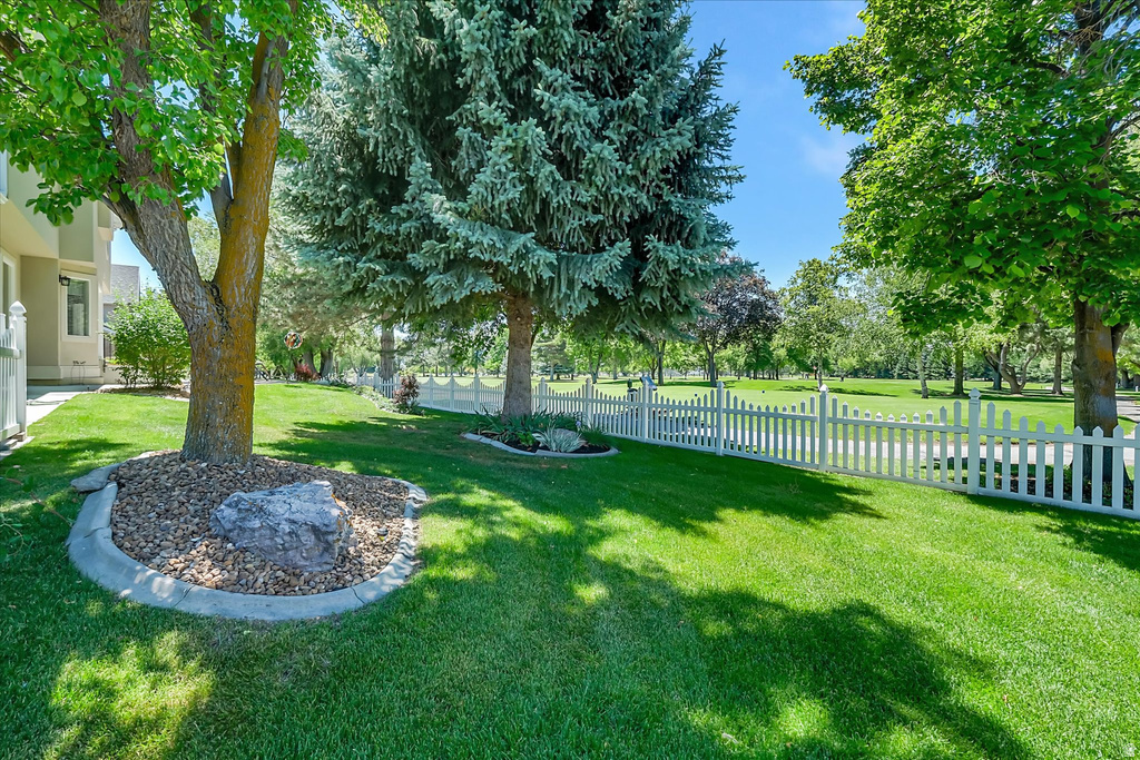 Expansive green lawn bordered by a white picket fence