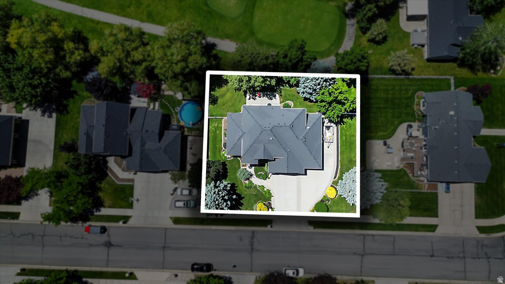Aerial perspective highlighting a multi-level roofline, extensive driveway with circular element, and mature landscaping