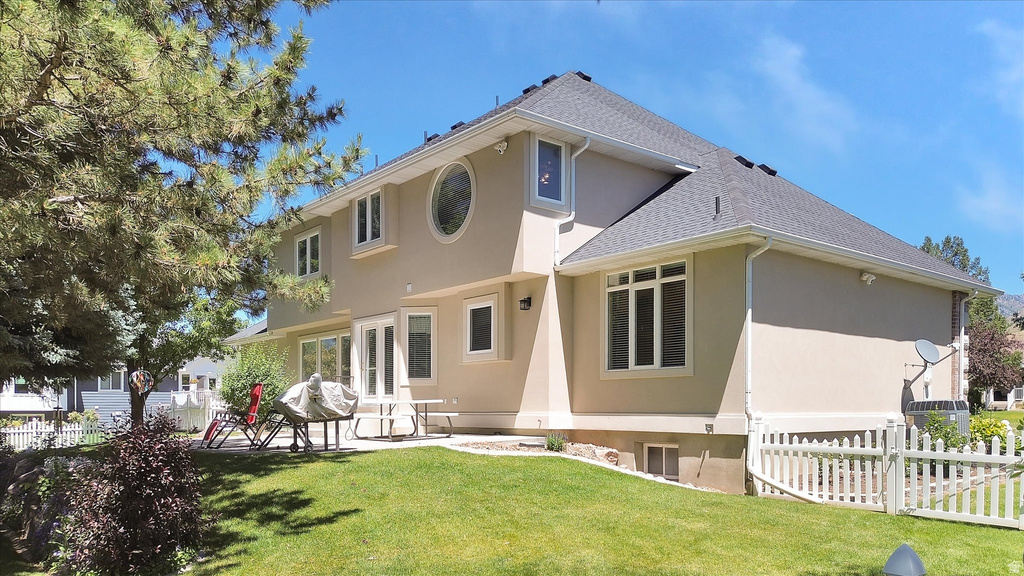 Stucco exterior residence with a shingle roof and white trim detailing