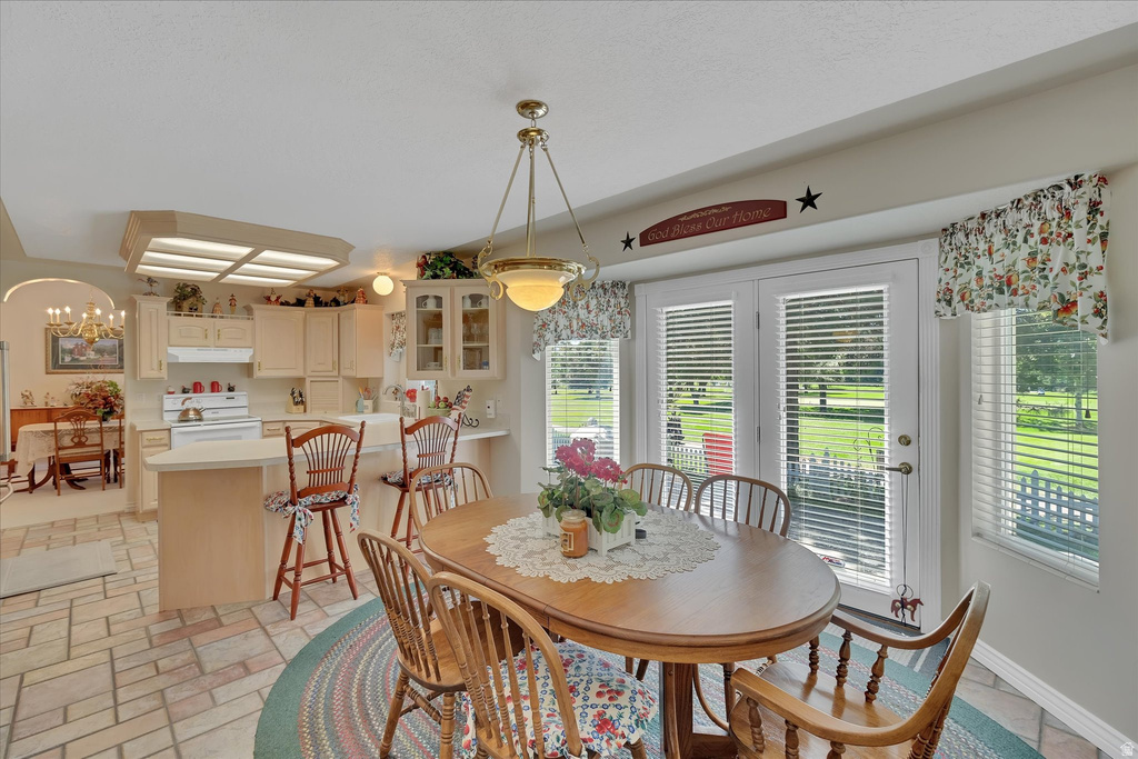 Kitchen with cream cabinetry, a white range, and a built-in microwave
