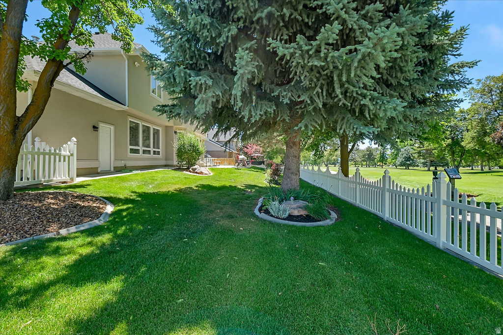 Expansive green lawn bordered by a white picket fence