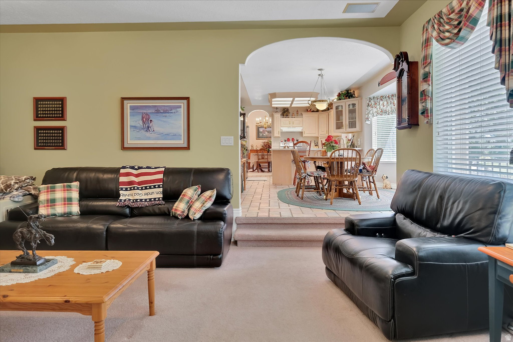 Arched entryways provide architectural interest, complementing the light-toned walls and carpet flooring