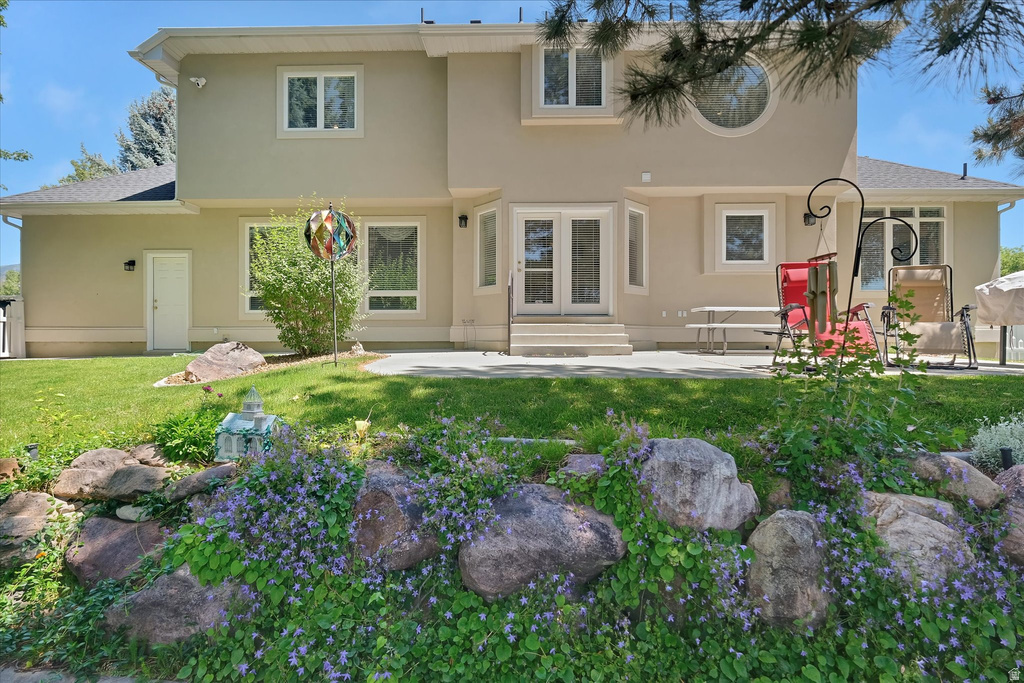 Stucco exterior with multiple white-framed windows, a prominent circular window, and a rear patio