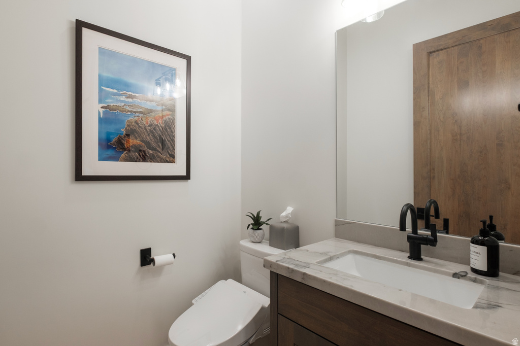Modern vanity with a rectangular undermount sink, stone countertop, and matte black faucet