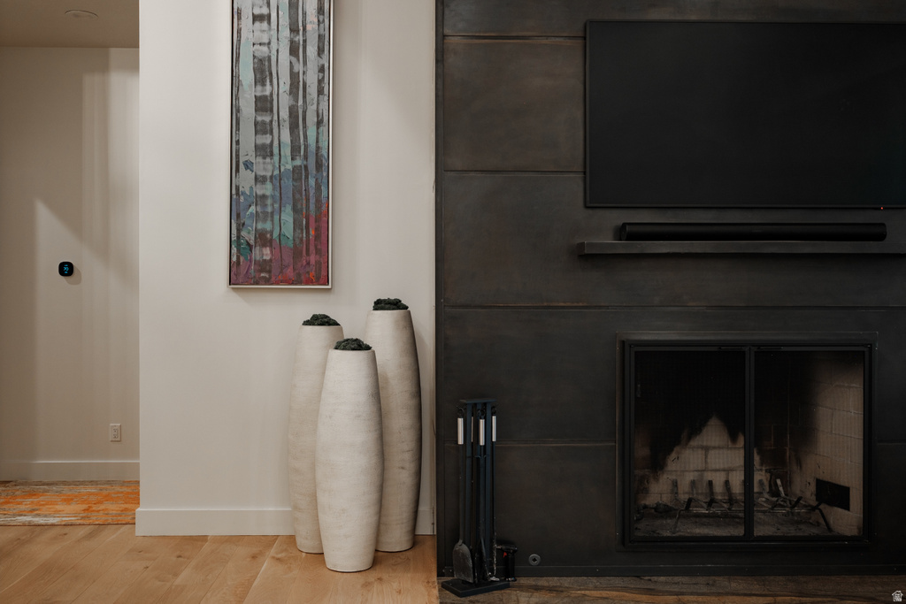 Contemporary fireplace with dark paneling, a mounted display, and integrated shelving