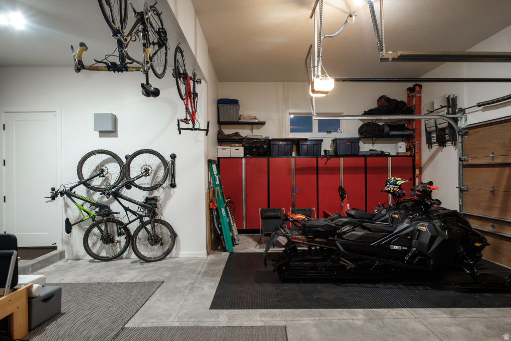Spacious garage featuring concrete flooring, built-in red cabinetry, and a wooden garage door
