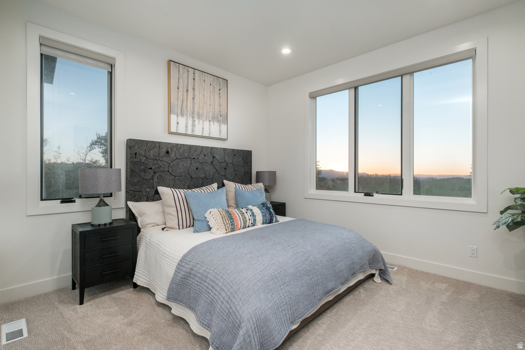 Spacious room featuring multiple large windows, recessed lighting, and soft carpet flooring