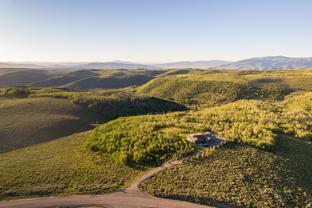 Expansive natural landscape featuring a private residence set among rolling hills and mature trees