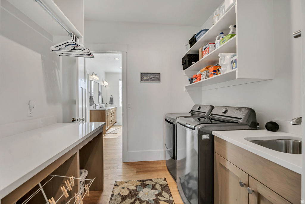 Dedicated laundry area featuring a stainless steel sink, built-in cabinetry, and open shelving