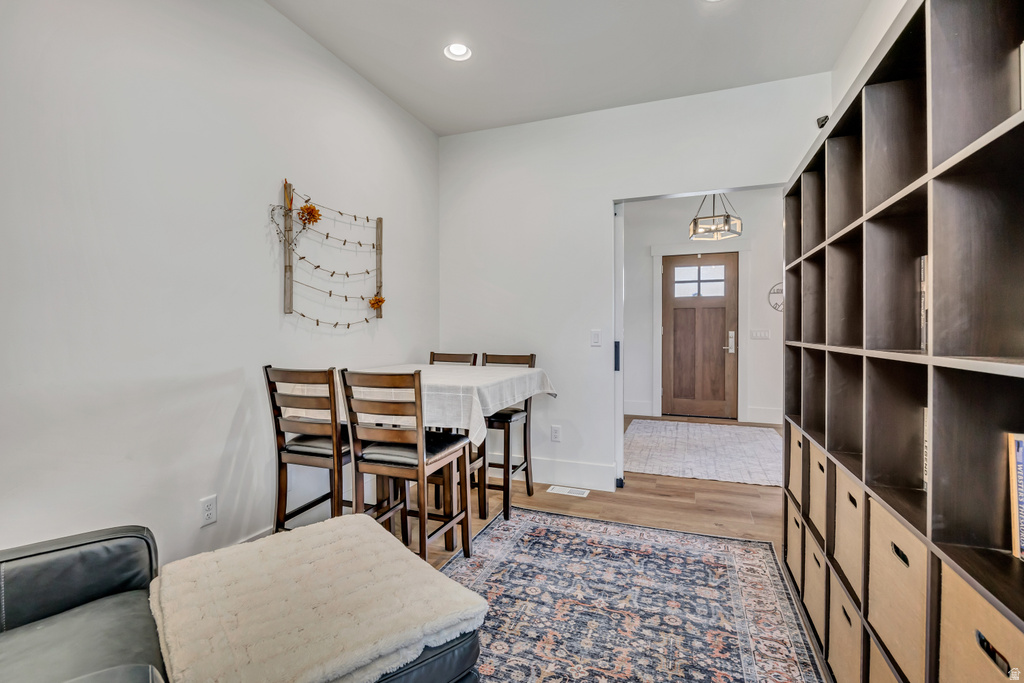 Integrated shelving unit with storage cubbies, wood-finish flooring, recessed lighting, and a solid wood front door with glass inserts