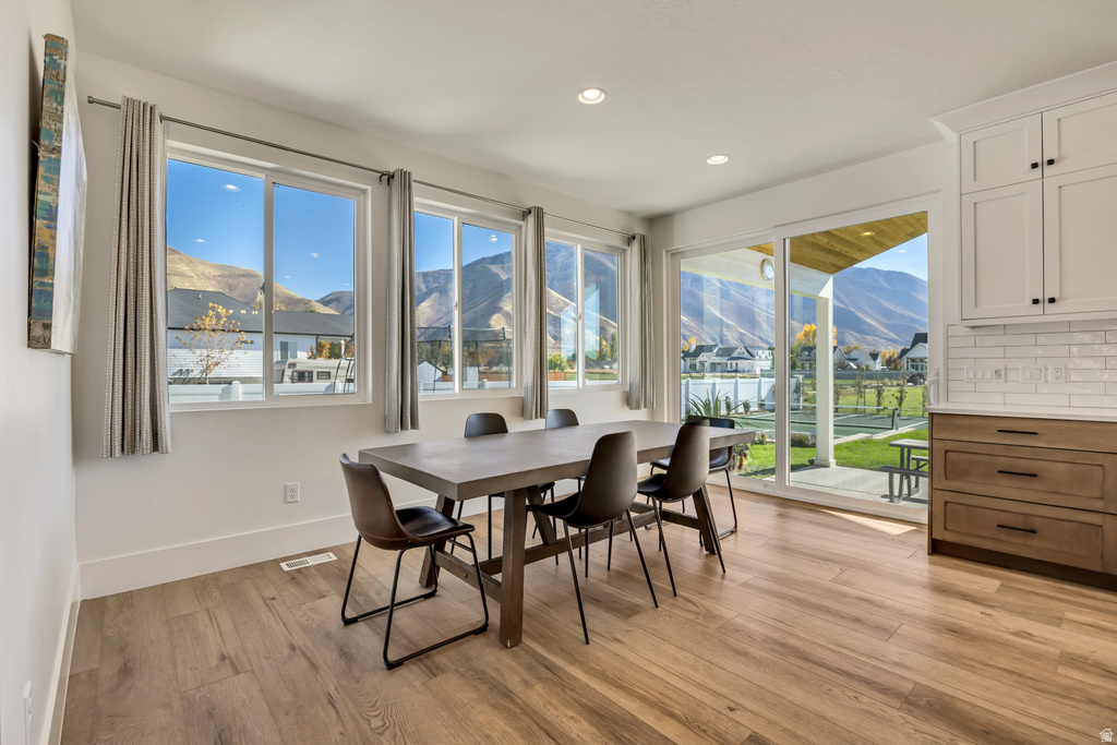 Dining area featuring multiple large windows and a sliding glass door, offering expansive mountain scenery