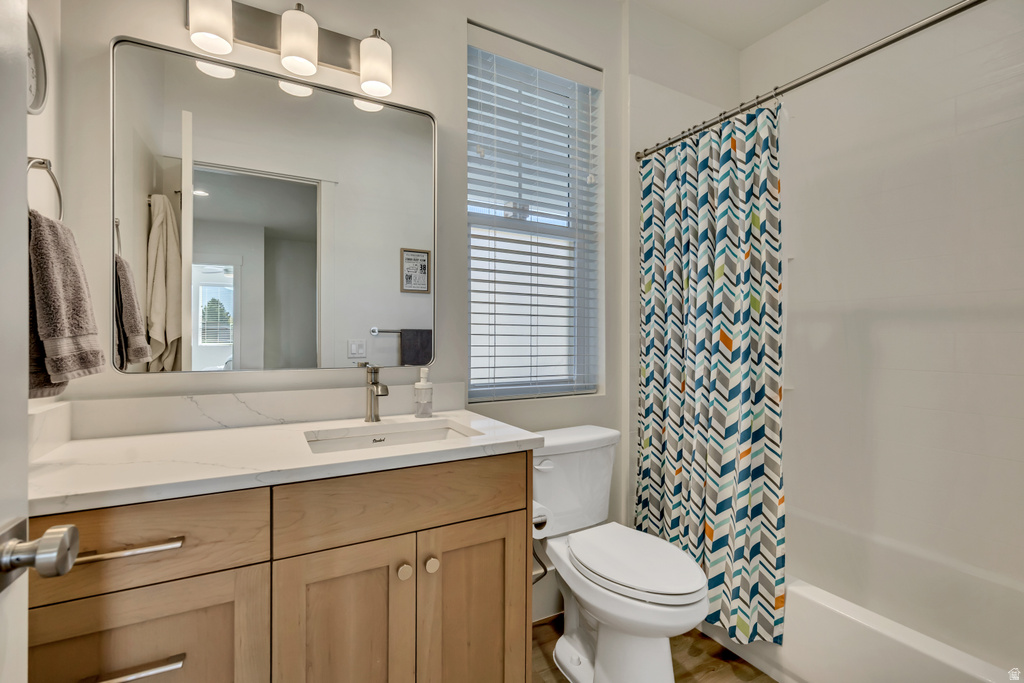 Full bathroom featuring a single vanity with wood cabinetry, a rectangular undermount sink, and a light-toned countertop