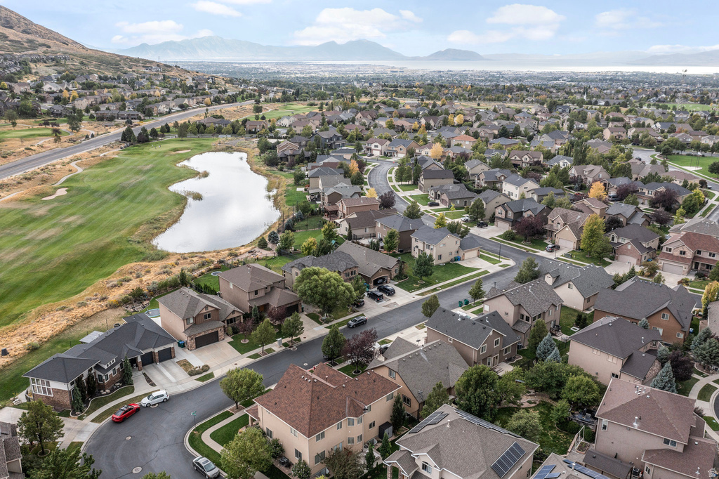 Residential area featuring a golf course, expansive lake, and mountain backdrop