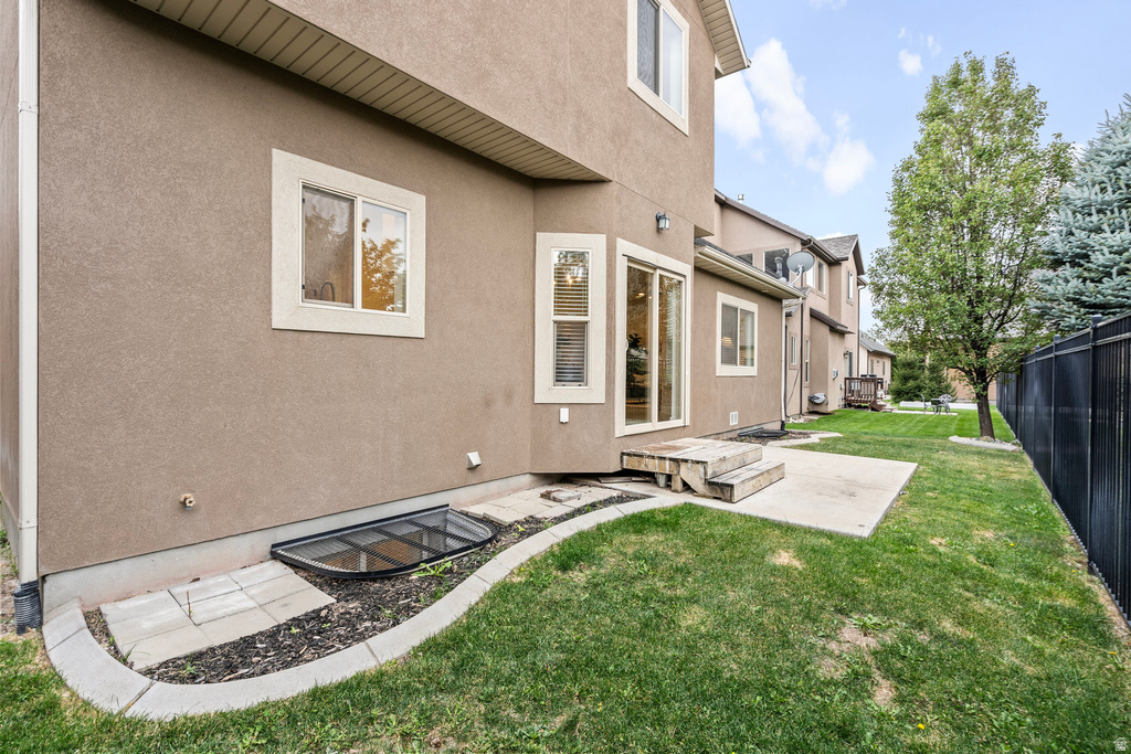 Stucco exterior with multiple windows and a sliding glass door leading to a concrete patio