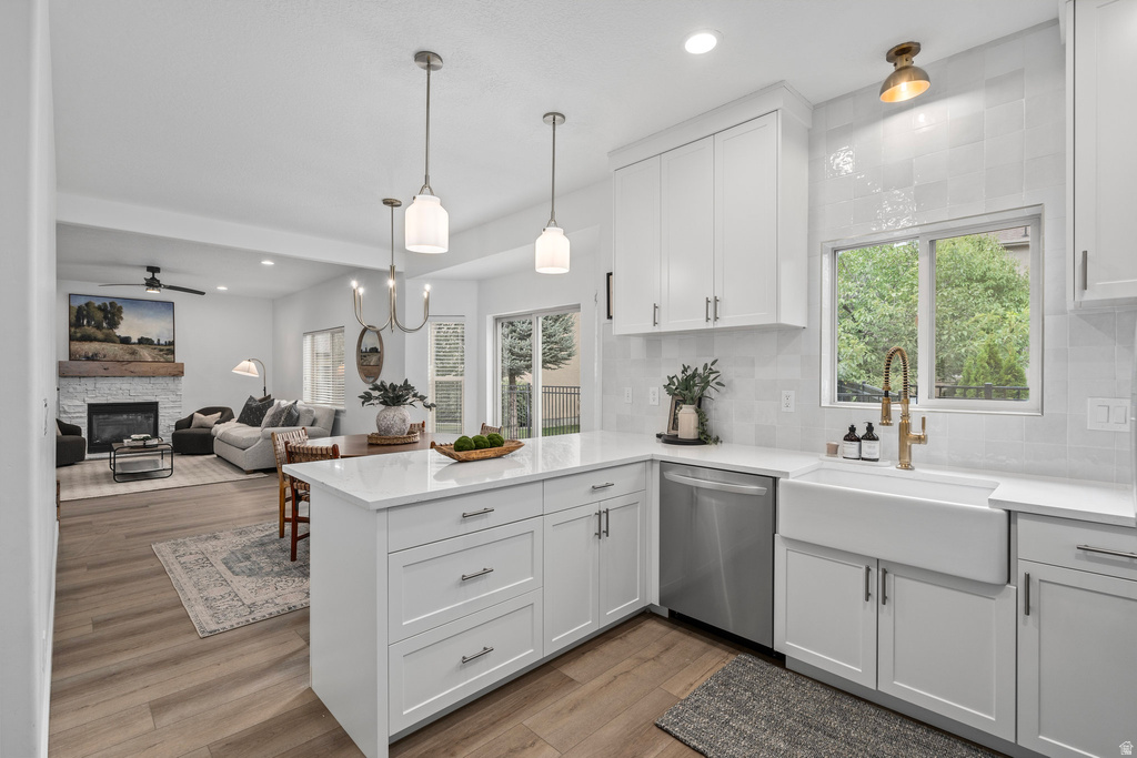 Modern kitchen featuring white shaker cabinetry, an apron-front sink with a brass faucet, and integrated stainless steel appliances