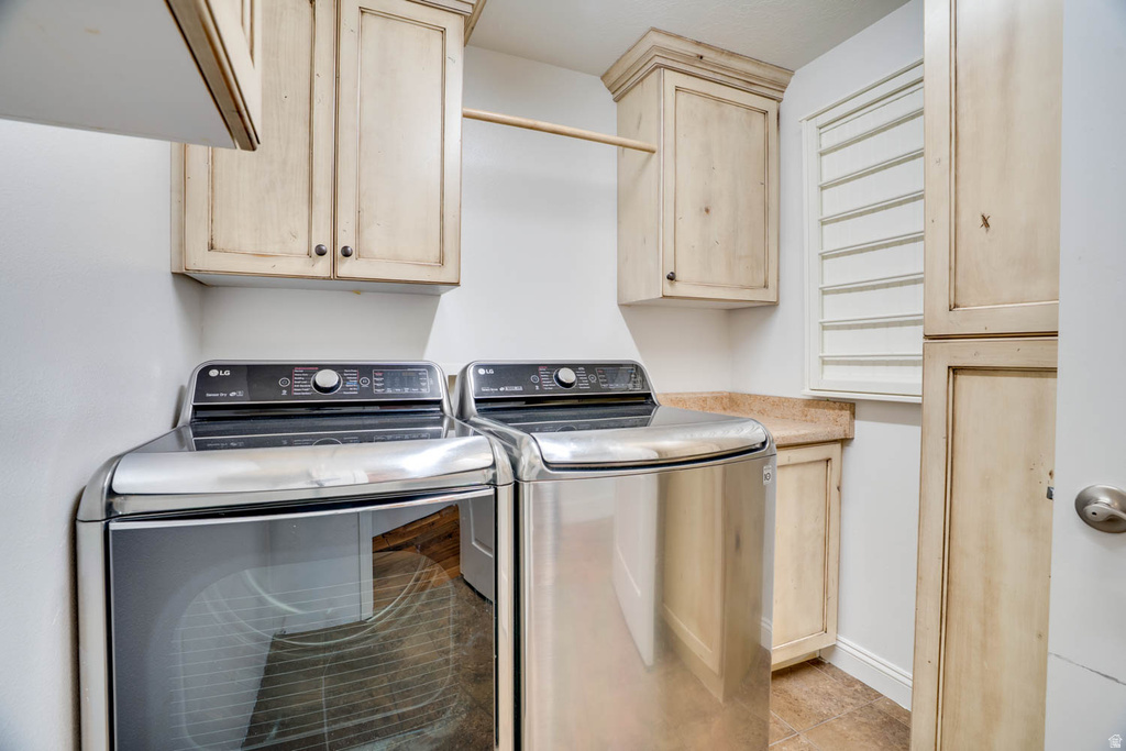 Dedicated laundry area featuring light-toned cabinetry, a built-in hanging rod, and a window with horizontal slat blinds