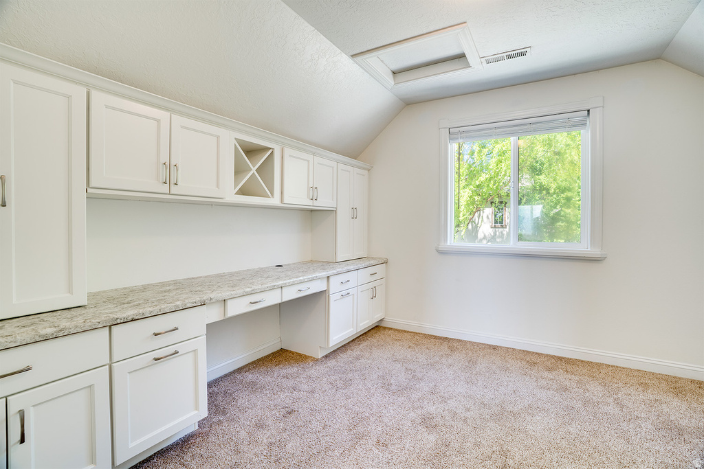 Built-in white cabinetry with a light-toned countertop and integrated desk space