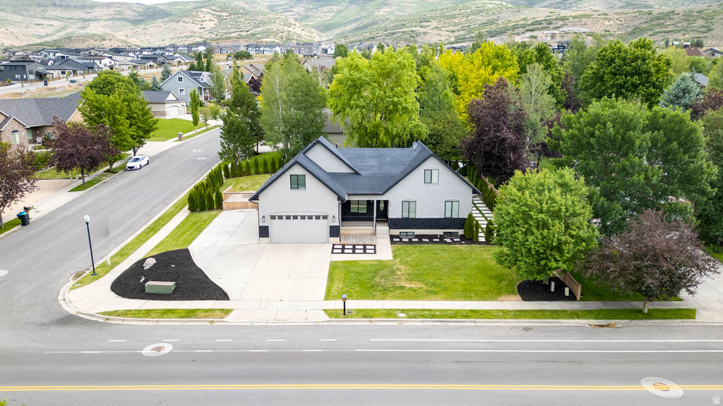 Contemporary residence featuring a two-car garage, dark-toned roof, and a light-colored exterior finish