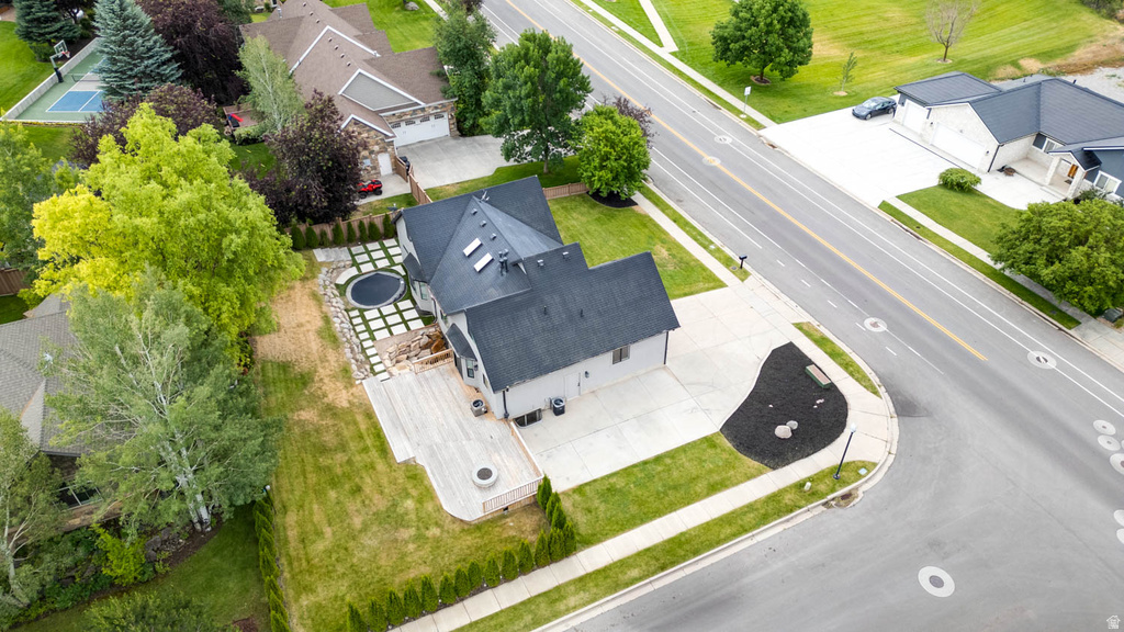 Expansive outdoor living space featuring a large wooden deck, built-in fire pit, and a paver patio with a circular inset