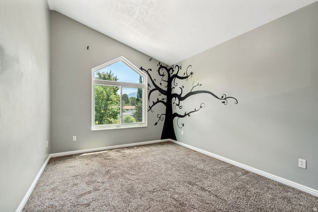 Room featuring vaulted ceilings and a distinctive arched window