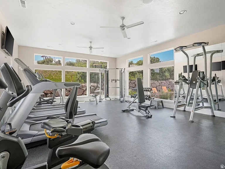 Fitness room featuring large picture windows, recessed lighting, ceiling fans, and a reflective mirrored wall