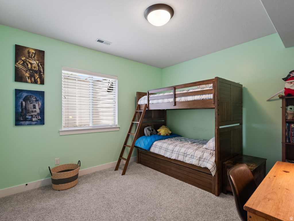 Carpeted room featuring a single window with blinds, light green walls, a flush-mount ceiling light, and white baseboards
