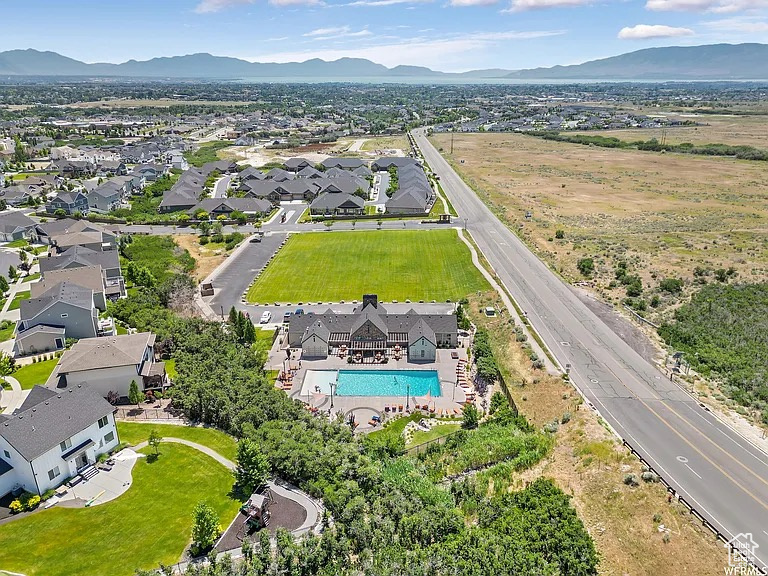 Aerial perspective showcasing a residential community with distant mountains and a body of water