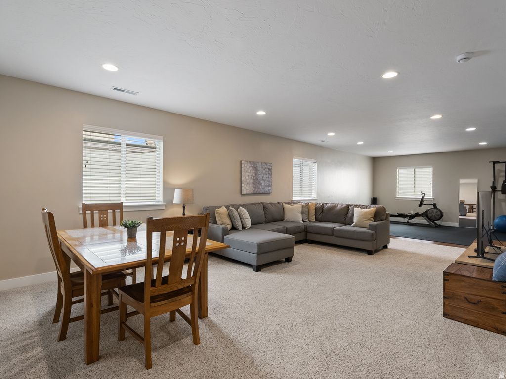 Spacious lower-level area with recessed lighting, multiple windows with blinds, and neutral-toned walls