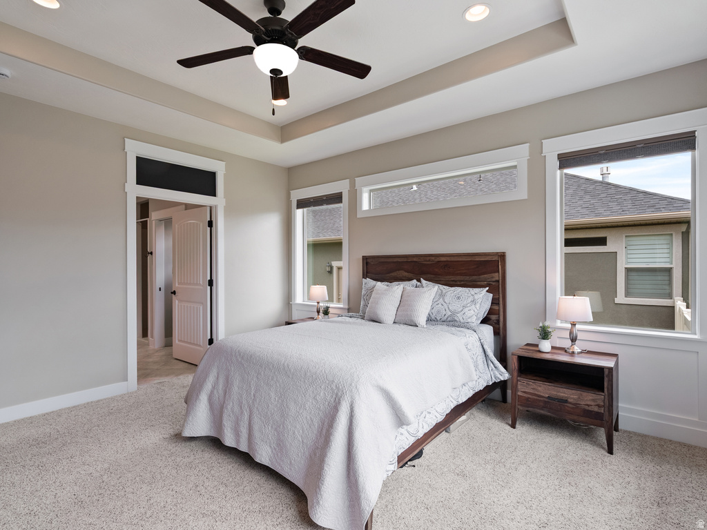 Bedroom featuring a tray ceiling with recessed lighting and a ceiling fan