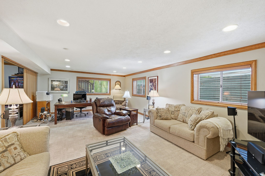 Carpeted room featuring recessed lighting, a built-in desk area, wood-trim windows, and crown molding