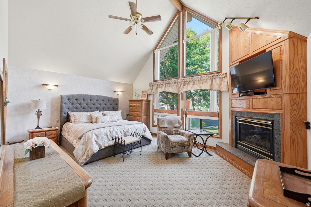 Vaulted ceiling interior featuring a ceiling fan, expansive windows with architectural angles, and a built-in entertainment center with a fireplace
