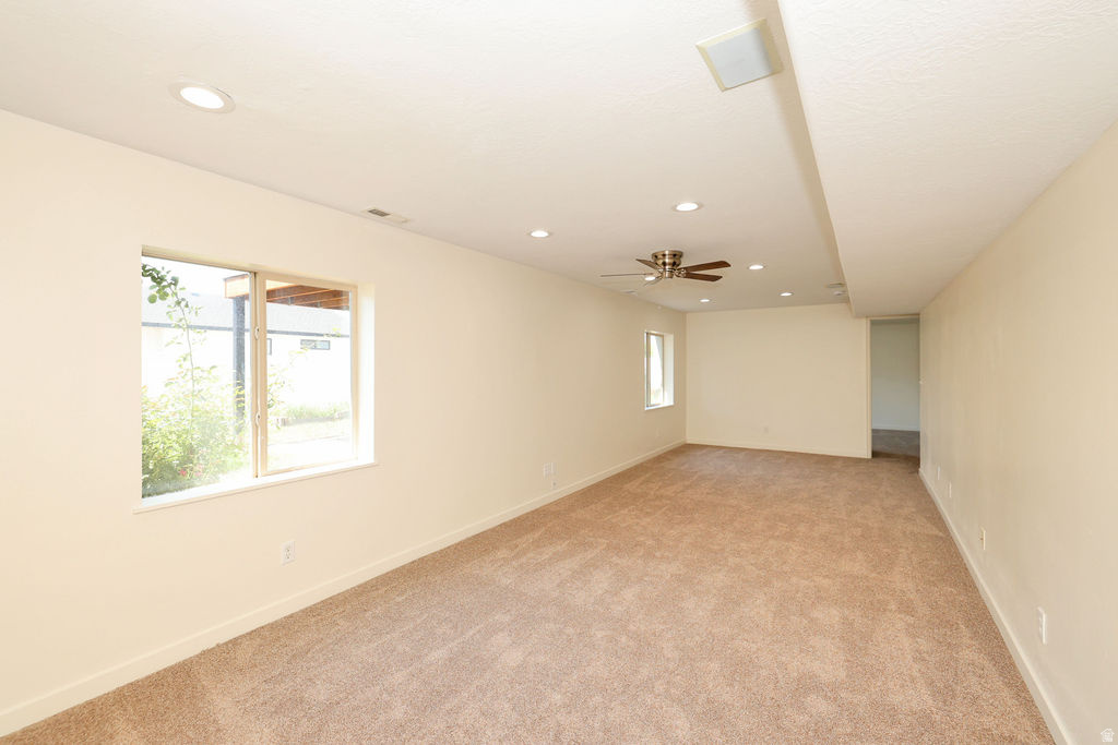 Spacious room with plush carpeting, recessed lighting, and a ceiling fan