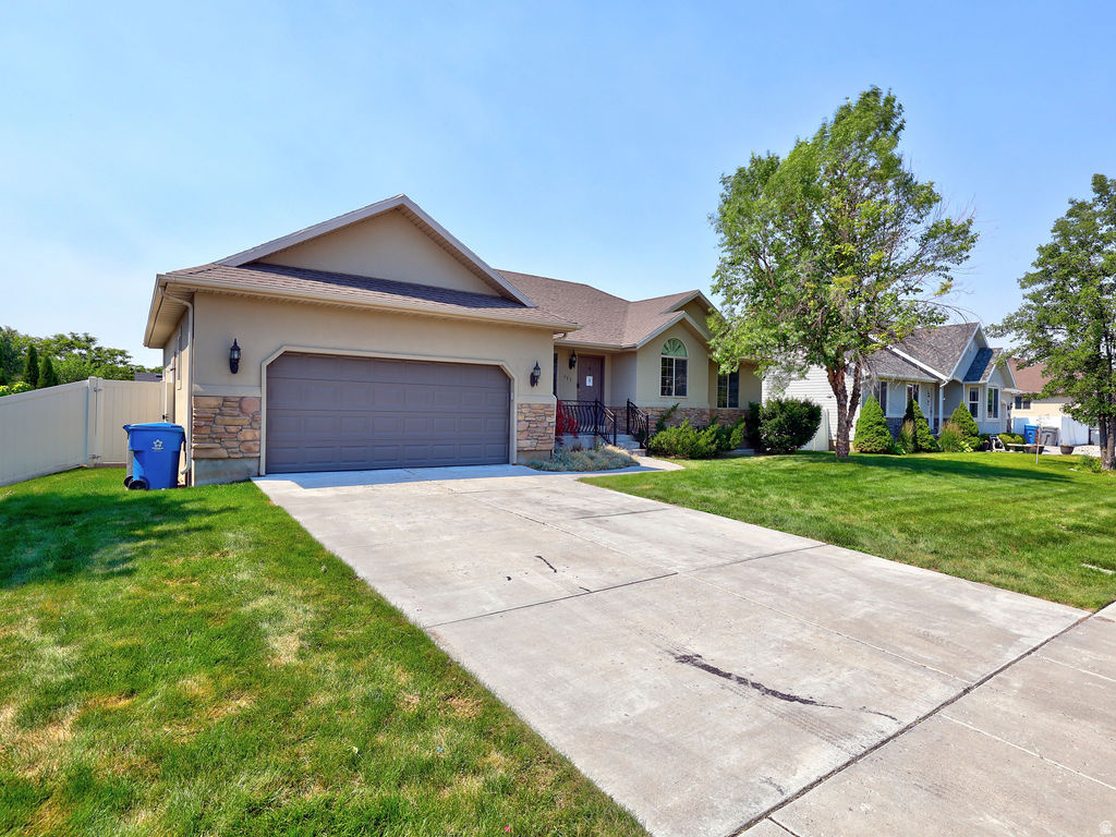 Single-story residence featuring a stucco exterior with stone accents, an attached two-car garage, and a concrete driveway