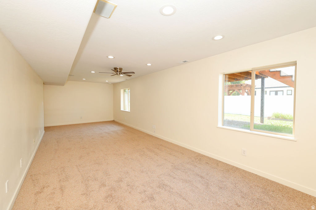Expansive room featuring recessed lighting, a ceiling fan, a window, and carpet flooring