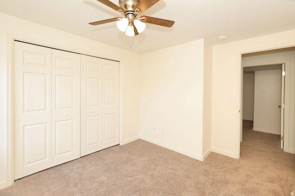 Neutral tone walls with a ceiling fan featuring wood-finish blades and integrated lighting