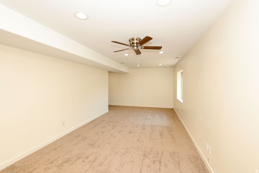 Carpeted room featuring a ceiling fan, recessed lighting, and a single window