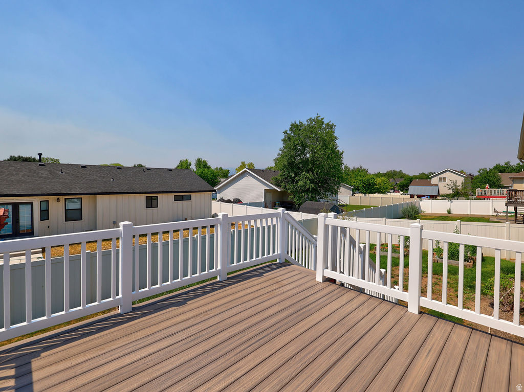 Composite decking with white vinyl railing, offering an elevated perspective of the backyard