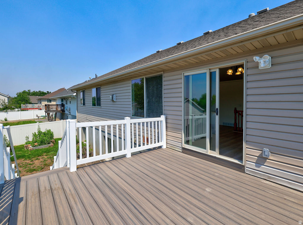 Spacious outdoor deck featuring composite decking, white railing, and sliding glass door access to the interior